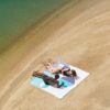 chico y chica tumbados en toallas de playa